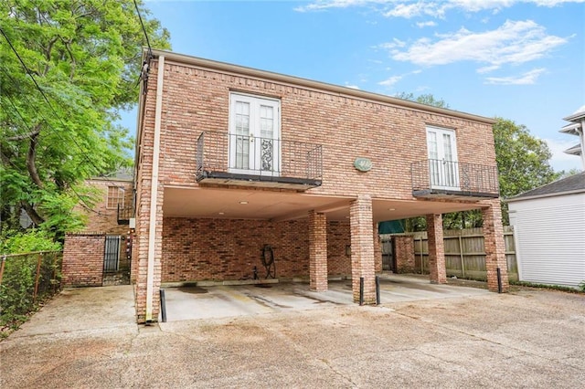4018 Pitt St, New Orleans, LA 70115 - back of property featuring a carport, fence, a balcony, brick siding, and driveway