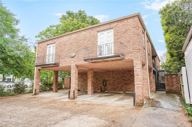 4018 Pitt St, New Orleans, LA 70115 - view of front of property featuring a carport, stairway, brick siding, and driveway