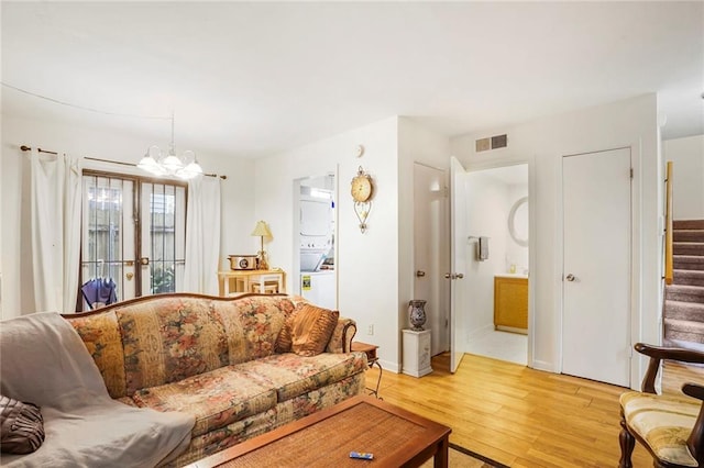 4018 Pitt St, New Orleans, LA 70115 - living room featuring baseboards, a chandelier, stairway, visible vents, and light wood finished floors