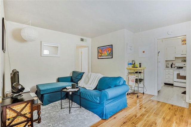 4018 Pitt St, New Orleans, LA 70115 - kitchen with baseboards, white appliances, light countertops, under cabinet range hood, and stacked washer / drying machine