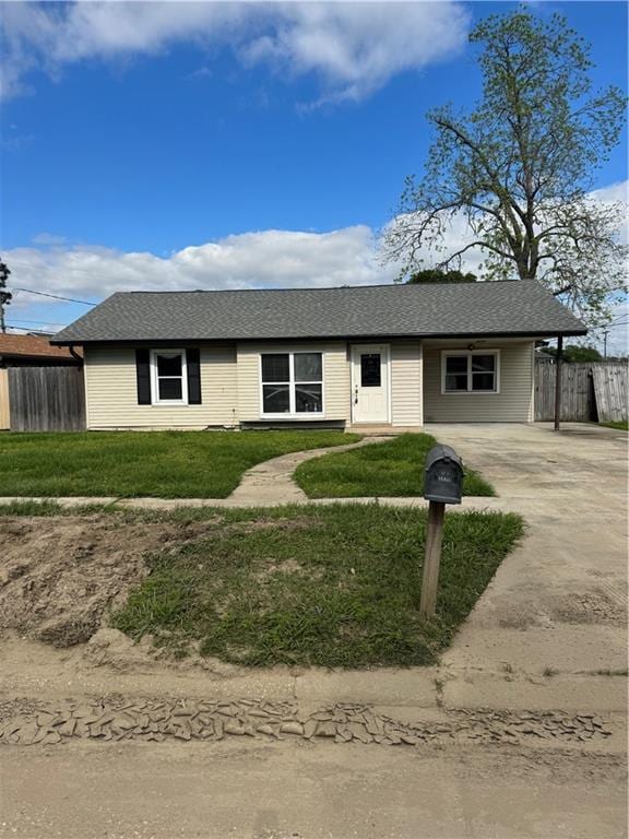 single story home with driveway, a front yard, and fence