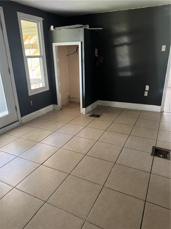 interior space with light tile patterned floors and baseboards