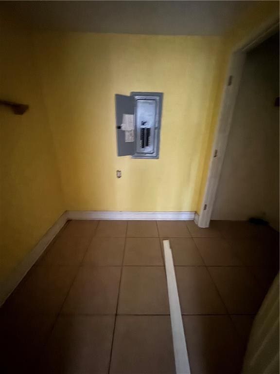interior space featuring baseboards, tile patterned flooring, and electric panel