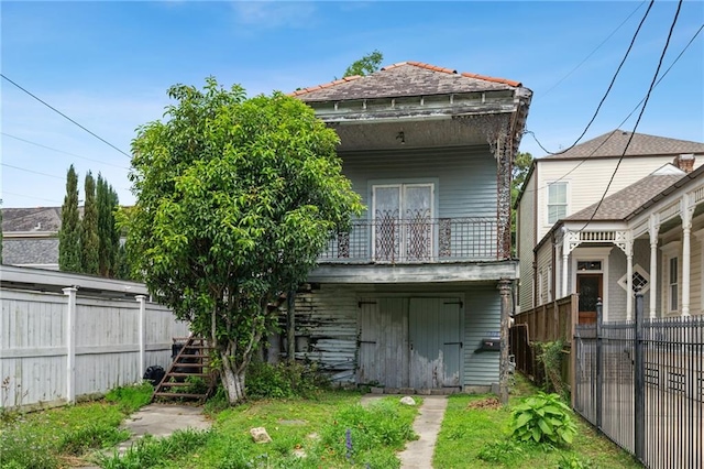 1318 Dublin St, New Orleans, LA 70118 - back of house featuring stairs, a balcony, and fence