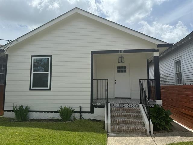 2417 Eagle St, New Orleans, LA 70118 - view of front of home featuring a front lawn, fence, and a porch