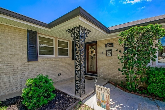 property entrance with brick siding and covered porch