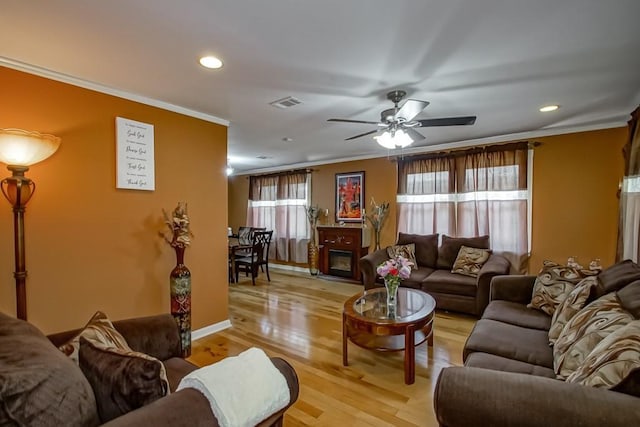 living area with visible vents, ornamental molding, a ceiling fan, recessed lighting, and light wood-style flooring
