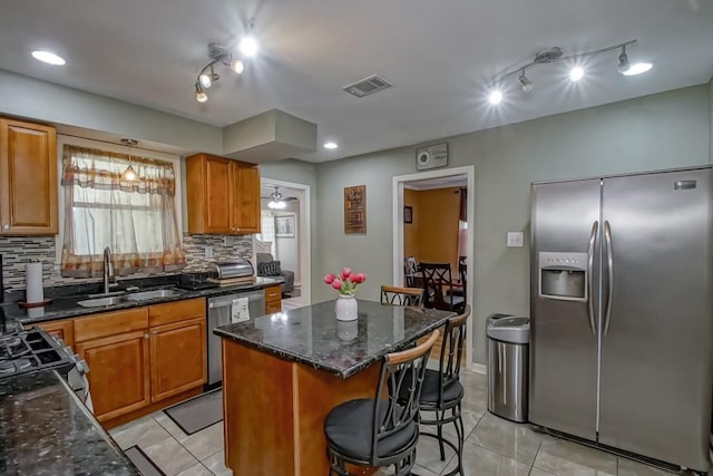 kitchen featuring decorative backsplash, stainless steel appliances, visible vents, and a sink