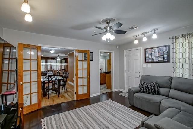 living area featuring visible vents, baseboards, ceiling fan, wood finished floors, and french doors