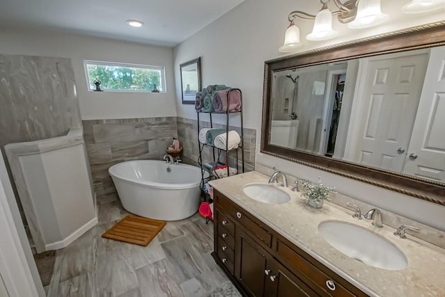 full bath with a soaking tub, a sink, double vanity, and tile walls