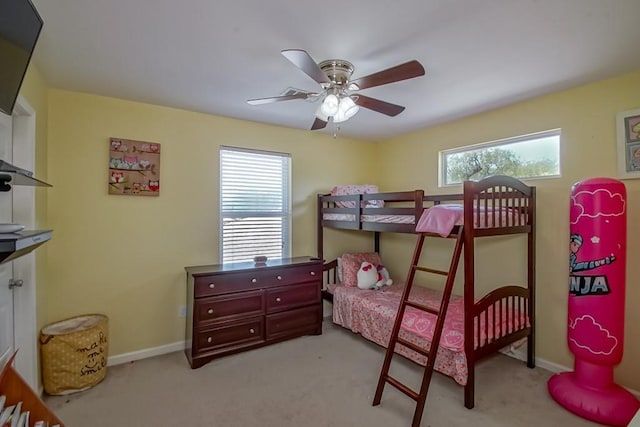 bedroom with ceiling fan, light colored carpet, and baseboards