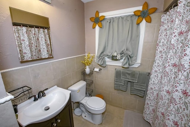 full bath with a wainscoted wall, toilet, tile walls, curtained shower, and vanity