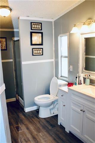 69476 S River Rd, Kentwood, LA 70444 - full bath with toilet, vanity, crown molding, and a stall shower