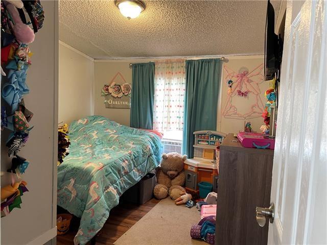 69476 S River Rd, Kentwood, LA 70444 - bedroom featuring a textured ceiling, crown molding, and wood finished floors