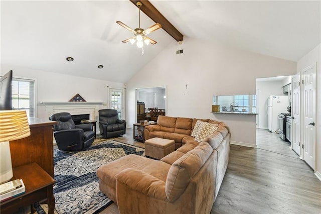 living area with ceiling fan, beamed ceiling, high vaulted ceiling, visible vents, and wood finished floors