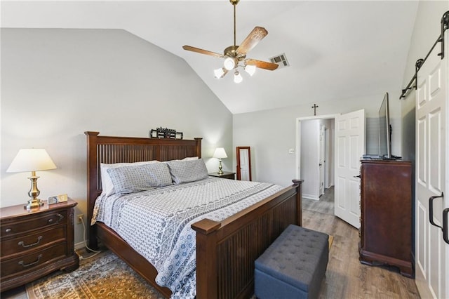 bedroom with visible vents, ceiling fan, vaulted ceiling, and wood finished floors