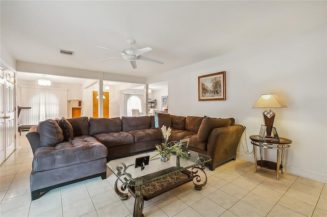 living area with light tile patterned floors, baseboards, a ceiling fan, and visible vents