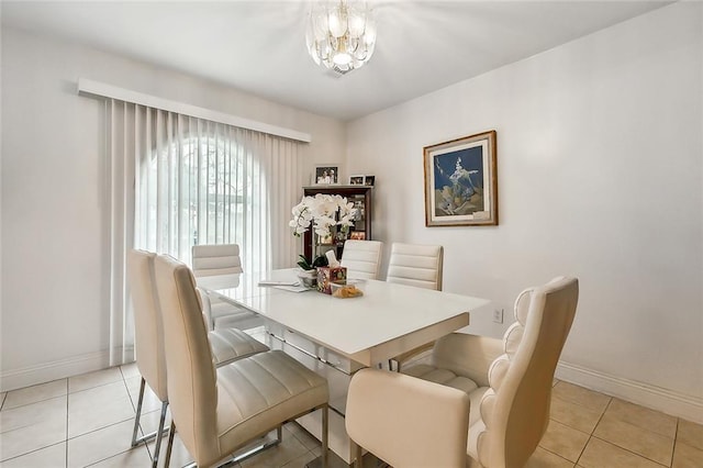 dining room with light tile patterned floors, baseboards, and an inviting chandelier