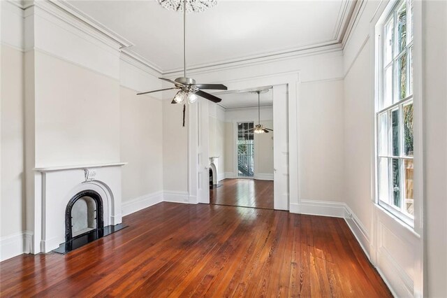101012 Philip St, New Orleans, LA 70130 - unfurnished living room featuring crown molding, dark wood-style floors, baseboards, ceiling fan, and a fireplace with flush hearth