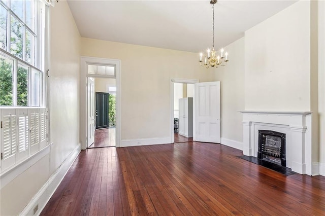 101012 Philip St, New Orleans, LA 70130 - unfurnished living room with a chandelier, dark wood-style flooring, a fireplace with flush hearth, and baseboards