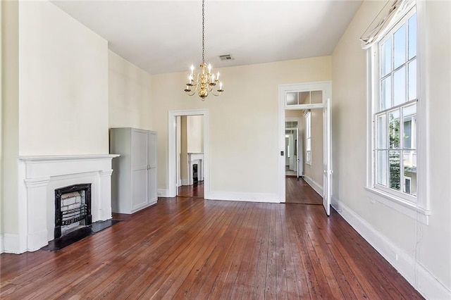 101012 Philip St, New Orleans, LA 70130 - unfurnished living room with a chandelier, dark wood-style floors, a fireplace, and baseboards