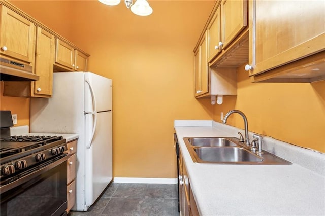 101012 Philip St, New Orleans, LA 70130 - kitchen featuring gas range oven, under cabinet range hood, a sink, light countertops, and baseboards