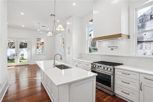 2623 Dauphine St, New Orleans, LA 70117 - kitchen featuring custom range hood, stainless steel range, a sink, and a healthy amount of sunlight