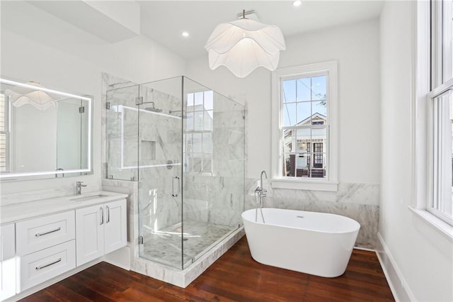 2623 Dauphine St, New Orleans, LA 70117 - bathroom featuring a marble finish shower, wood finished floors, a freestanding bath, vanity, and tile walls