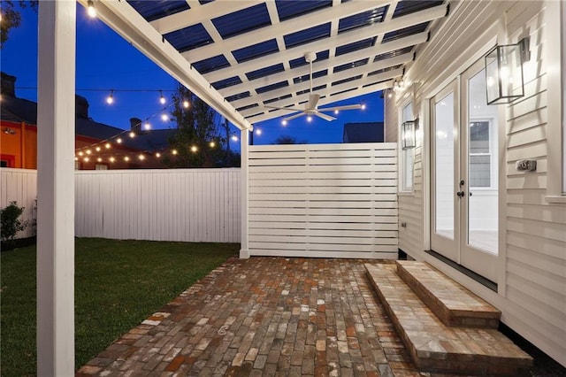2623 Dauphine St, New Orleans, LA 70117 - patio at night featuring a ceiling fan, a fenced backyard, french doors, and a patio