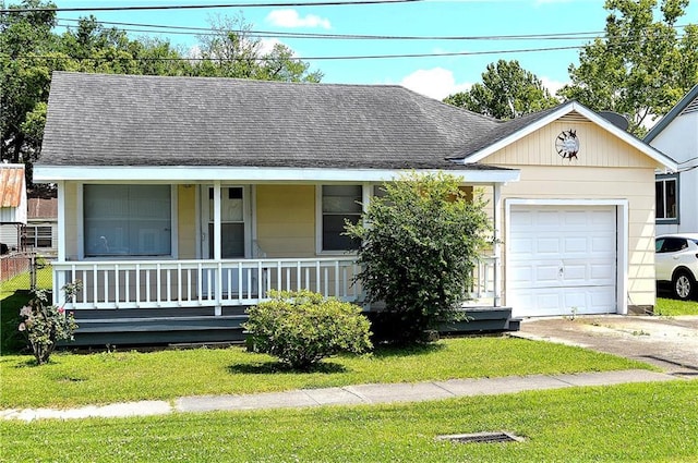 607 Central Ave, Westwego, LA 70094 - view of front of property with concrete driveway, roof with shingles, a front lawn, an attached garage, and a porch