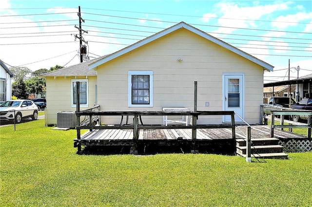 607 Central Ave, Westwego, LA 70094 - back of property featuring a deck, central air condition unit, fence, and a lawn