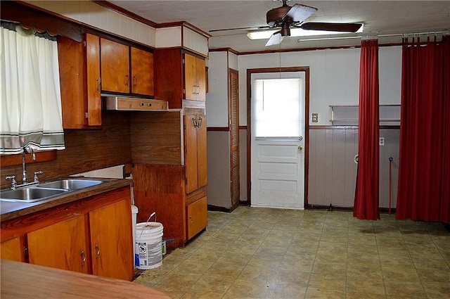 607 Central Ave, Westwego, LA 70094 - kitchen with ceiling fan, under cabinet range hood, a sink, wainscoting, and brown cabinets