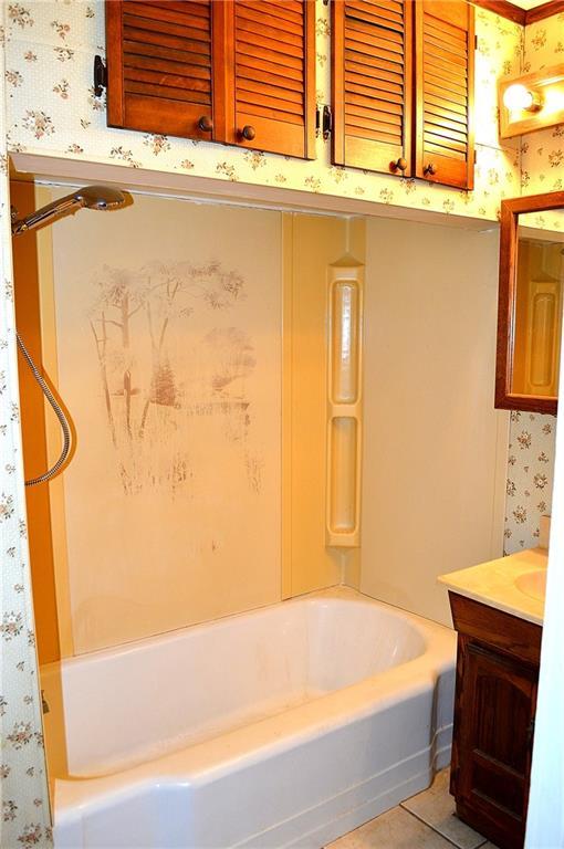 607 Central Ave, Westwego, LA 70094 - bathroom featuring shower / bathtub combination, vanity, and wallpapered walls
