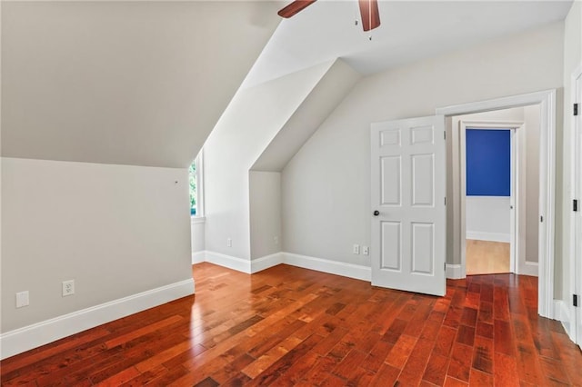 additional living space with baseboards, vaulted ceiling, a ceiling fan, and wood finished floors