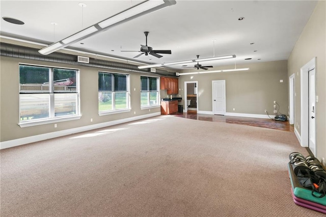 empty room with baseboards, ceiling fan, dark colored carpet, and visible vents