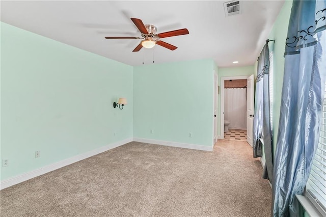 unfurnished bedroom with connected bathroom, a ceiling fan, visible vents, carpet floors, and baseboards