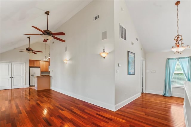 unfurnished living room featuring visible vents, ceiling fan, high vaulted ceiling, and wood-type flooring