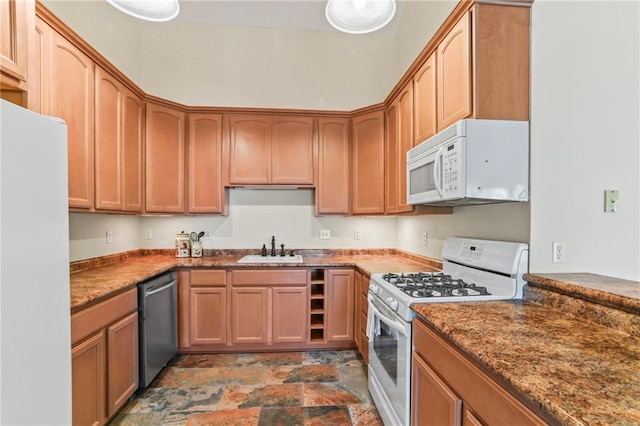 kitchen with stone counters, white appliances, stone finish floor, and a sink