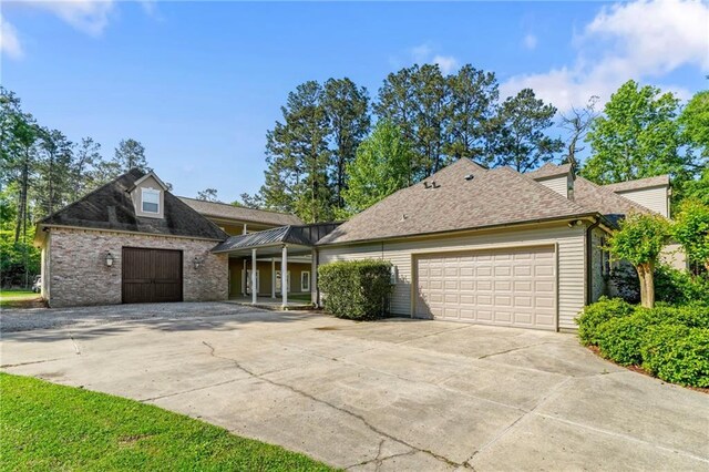 view of front of home with an attached garage, a shingled roof, and concrete driveway