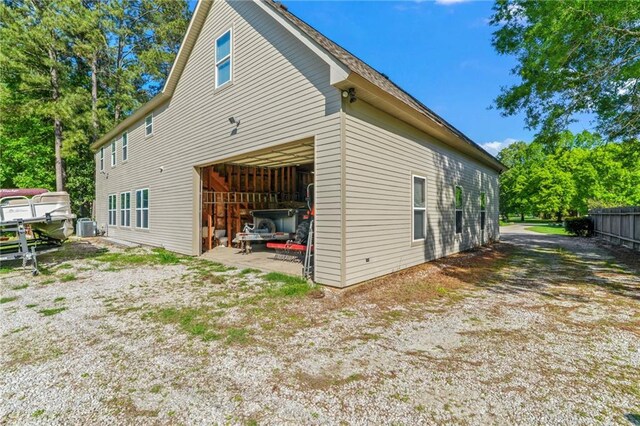 view of side of property with a garage and central AC