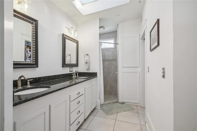 full bathroom with tile patterned floors, a sink, a stall shower, and a skylight