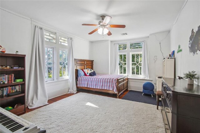 bedroom with visible vents, ceiling fan, and dark wood finished floors