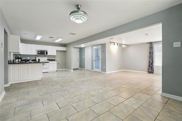 3408 Lake Villa Dr, Metairie, LA 70002 - kitchen with appliances with stainless steel finishes, a peninsula, white cabinets, and dark countertops