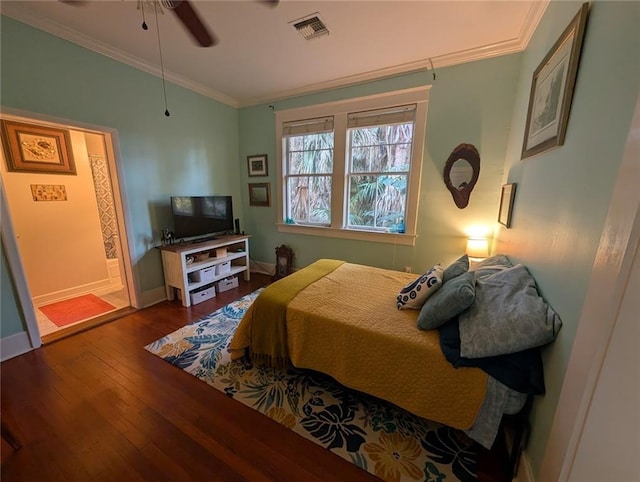 bedroom with a ceiling fan, crown molding, hardwood / wood-style flooring, baseboards, and visible vents
