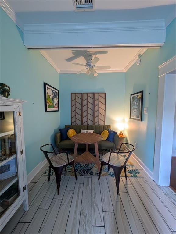 dining room with wood finished floors, crown molding, baseboards, and a ceiling fan