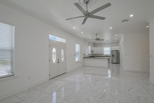 entryway featuring visible vents, ceiling fan, baseboards, and a healthy amount of sunlight