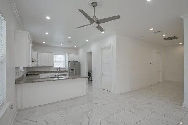 kitchen with stainless steel fridge with ice dispenser, a ceiling fan, light stone countertops, visible vents, and marble finish floor