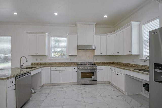 kitchen with ornamental molding, under cabinet range hood, marble finish floor, a sink, and stainless steel appliances