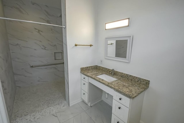 bathroom with a marble finish shower, baseboards, marble finish floor, and vanity