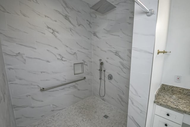 bathroom with a marble finish shower and vanity